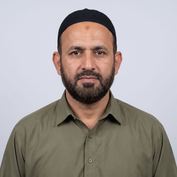 Man wearing a kippah, full face visible, against a plain pale background