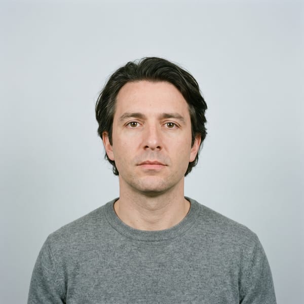 A compliant document photo: even light, plain background, neutral expression